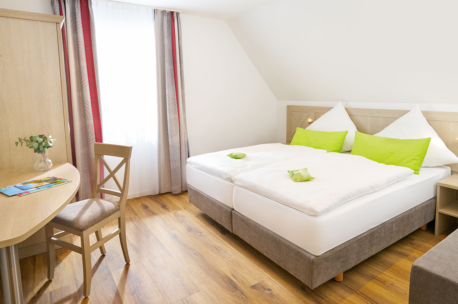 Ferien-Apartment Sauerland Haus Dumicketal Helles Schlafzimmer im Ferien-Apartment mit Doppelbett, Stuhl und grünen Akzenten