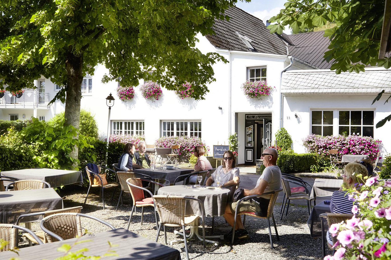 Hotel Restaurant Sauerland Haus Dumicketal Außenbereich des Haus Dumicketal mit Gästen im Biergarten vor dem Hotel