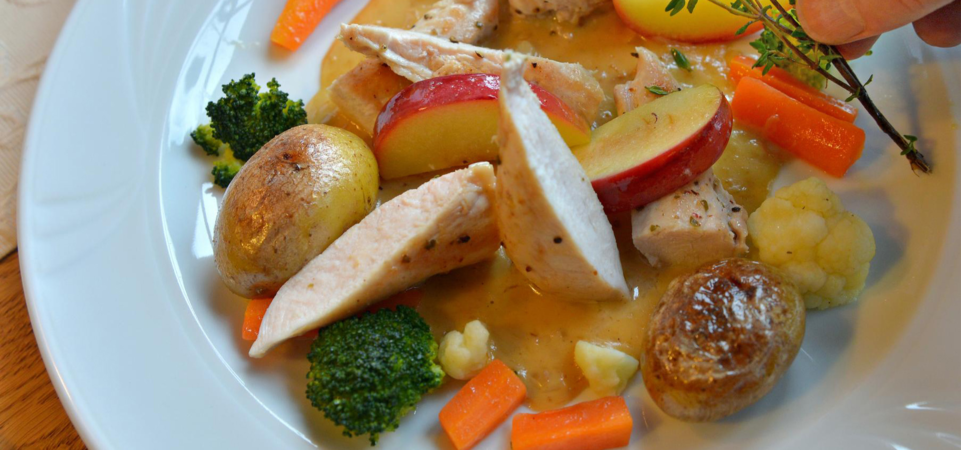 Hausgemachtes Gericht mit Fleisch, Apfel, Gemüse und Sauce auf einem Teller