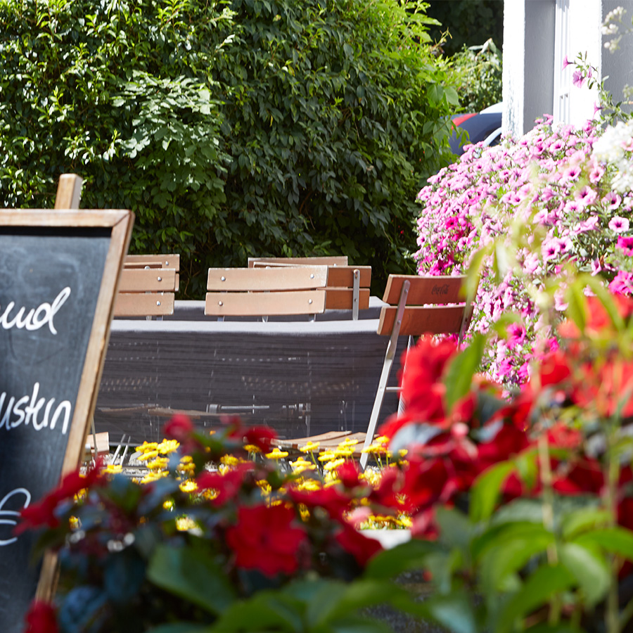 Biergarten Sauerland Haus Dumicketal Außenbereich des Haus Dumicketal mit Blumen, Tafel und Sitzplätzen