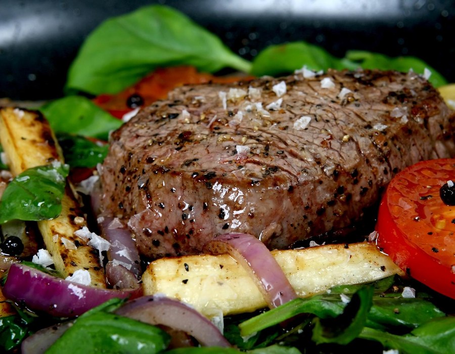 Gegrilltes Steak mit Gemüse und Beilagen auf einem Teller