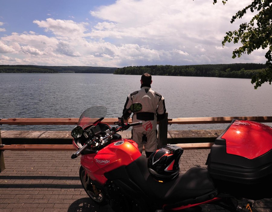 Biker Hotel Sauerland mit Tourentipps Rotes Motorrad an einem Aussichtspunkt mit Blick auf den See