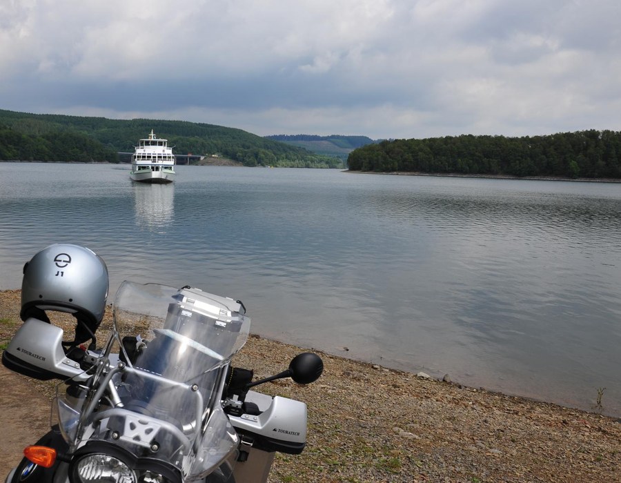 Motorradtour Biggesee Sauerland Haus Dumicketal Motorrad am Ufer des Biggesees mit Ausflugsschiff auf dem Wasser