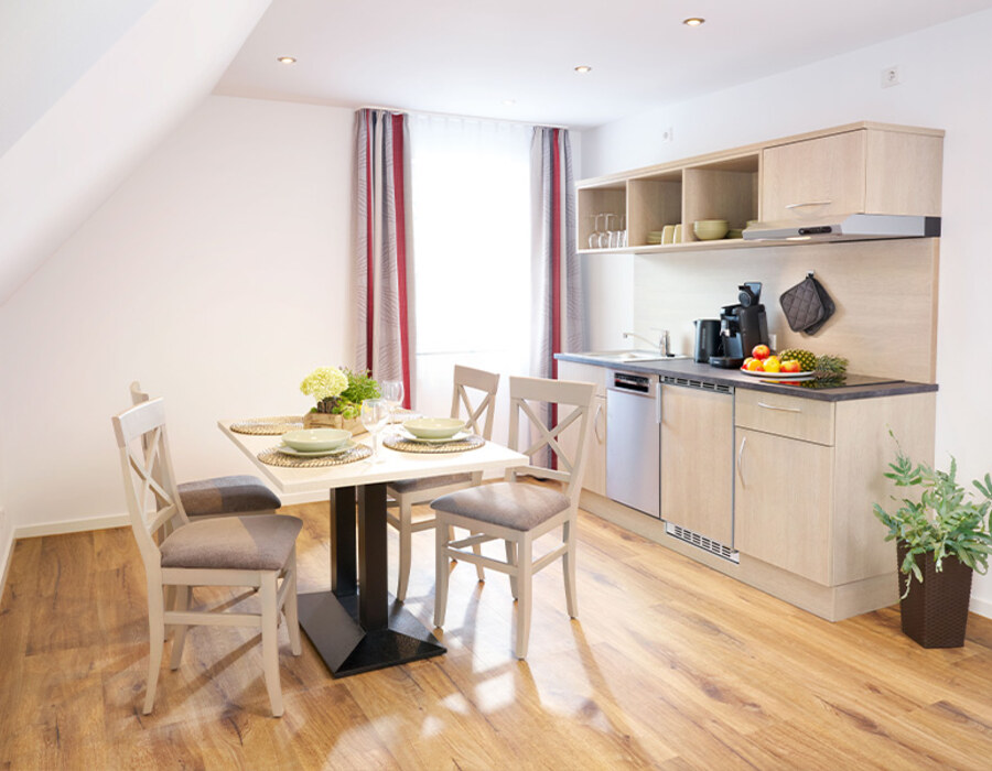Helle Wohnküche im Ferien-Apartment mit Esstisch, Küchenzeile und moderner Einrichtung