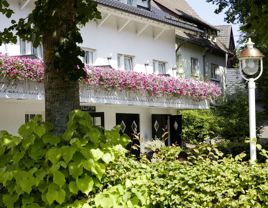 Außenansicht des Haus Dumicketal mit Balkon, Blumen und grüner Umgebung
