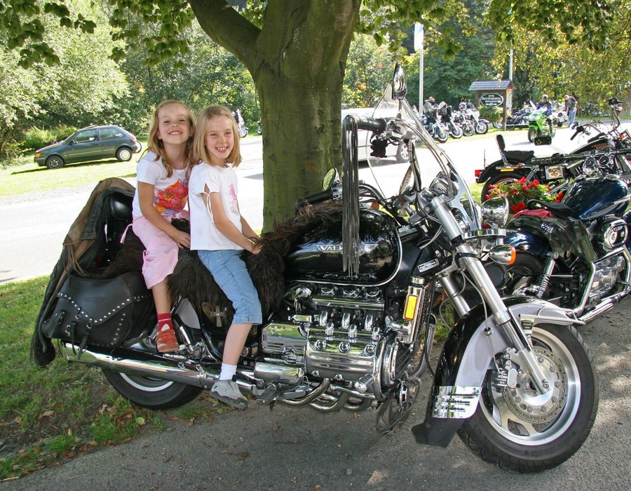 Motorradurlaub unter der Woche Sauerland Zwei Personen sitzen auf einem Motorrad bei einem Bikertreffen im Sauerland