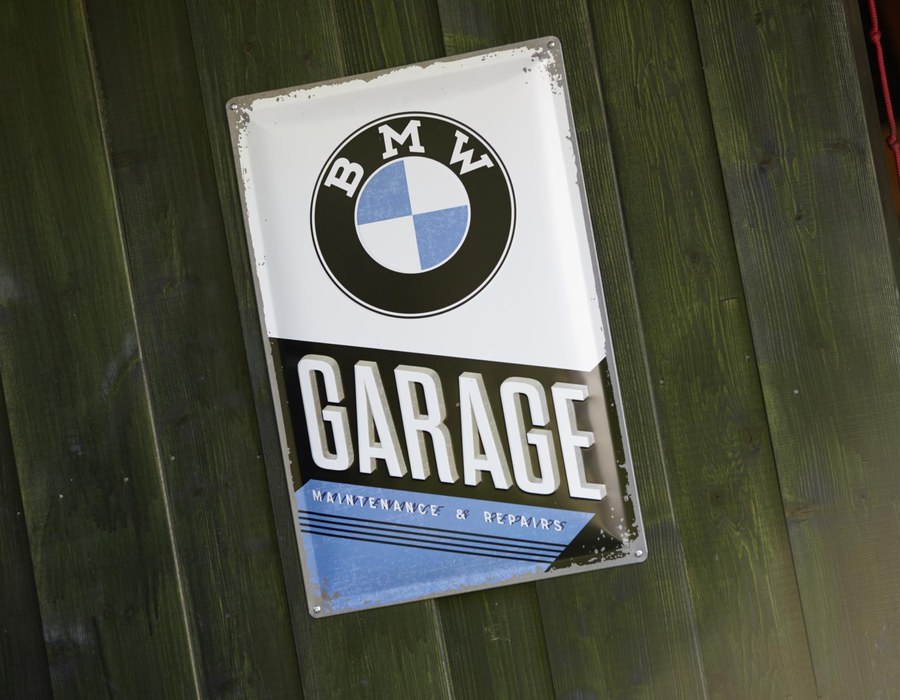 BMW Garage Schild an einer grünen Holzwand