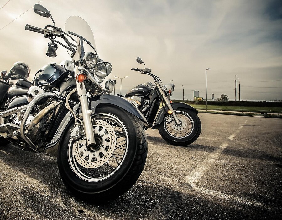 Biker Hotel Sauerland Haus Dumicketal Mehrere Motorräder stehen auf einem Parkplatz vor bewölktem Himmel