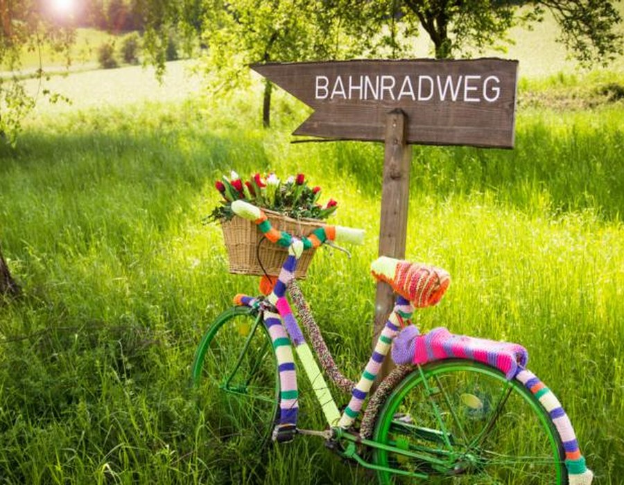 Buntes Fahrrad an einem Schild mit der Aufschrift Bahnradweg
