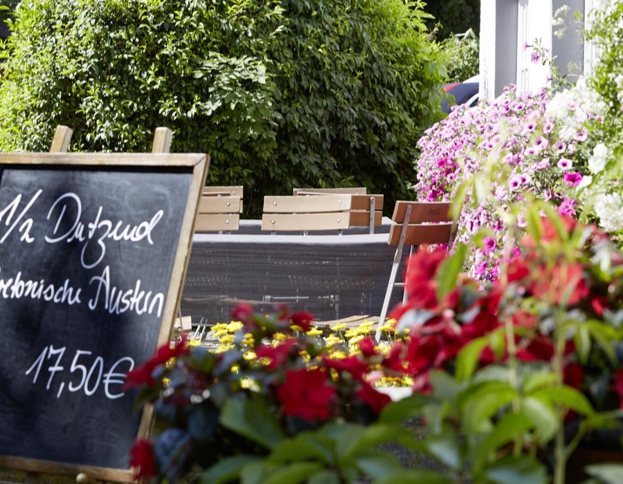 Erholungsurlaub Sauerland Haus Dumicketal Außenbereich des Haus Dumicketal mit Blumen, Tafel und Sitzplätzen