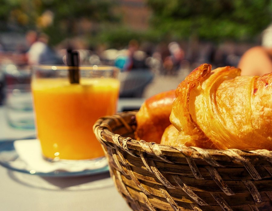 Frühstücksbuffet Sauerland Haus Dumicketal Frühstück mit Brötchenkorb, Croissant und Orangensaft auf einem Tisch