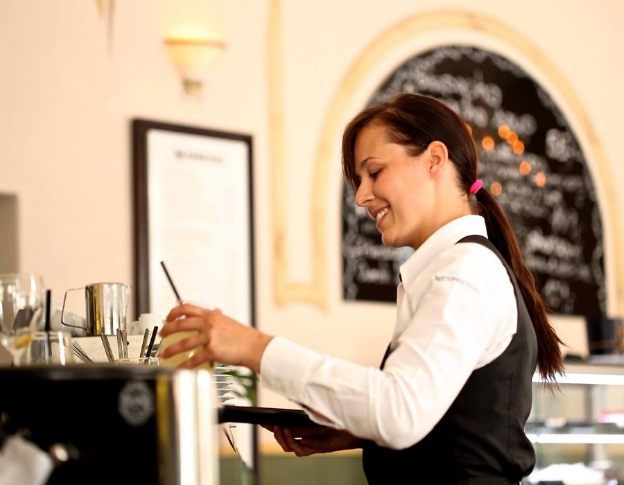 Servicekraft im Restaurant beim Servieren von Getränken
