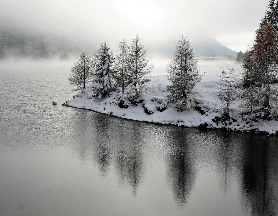 Winterurlaub Sauerland am See Winterlicher See mit verschneiten Bäumen, Nebel und ruhiger Wasserfläche
