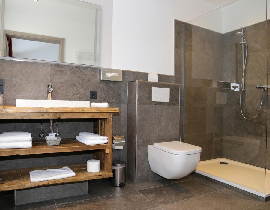 Modernes Badezimmer mit Waschbecken, Dusche, WC und Holzregal